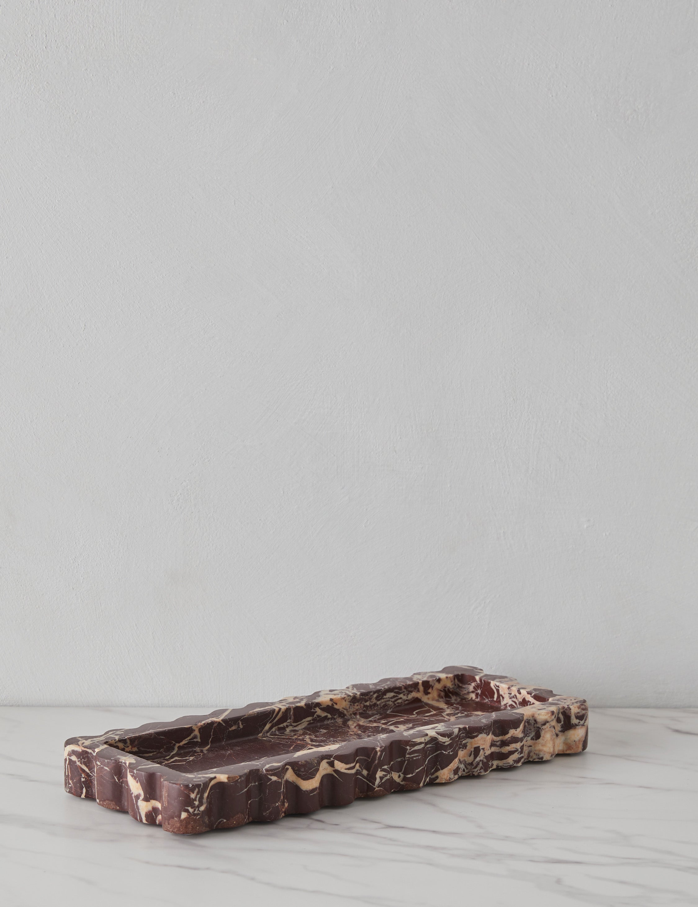 Angled view of the 512 long scalloped decorative tray in cherry marble