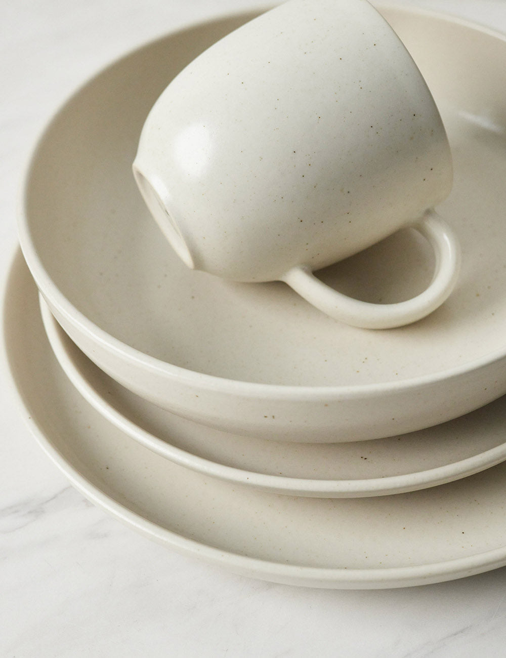 Angled view of the Pacifica Vanilla-toned Dinnerware 5-Piece Place Setting by Casafina