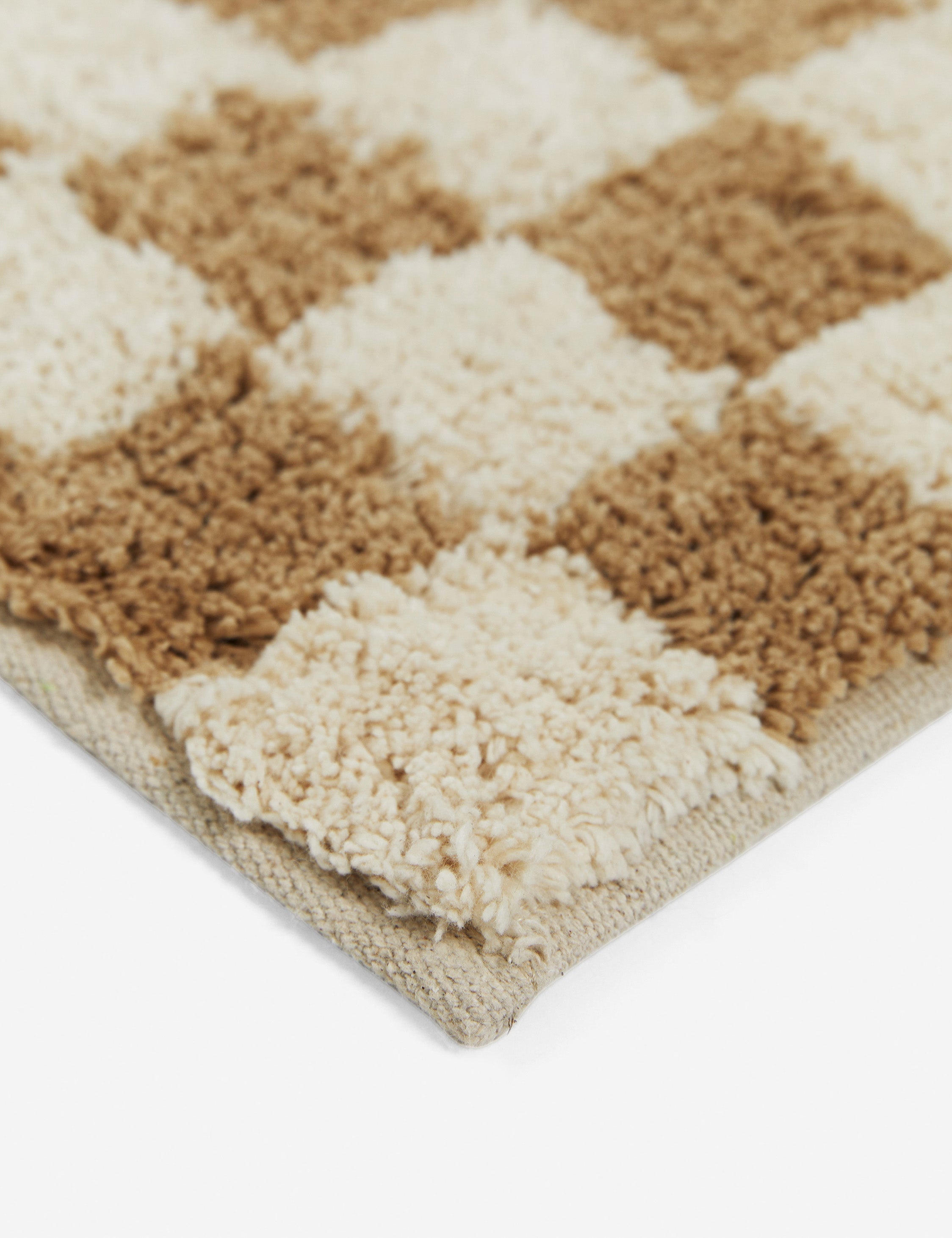 Close up corner view of the Two-tone checkerboard bath mat by Sarah Sherman in café brown