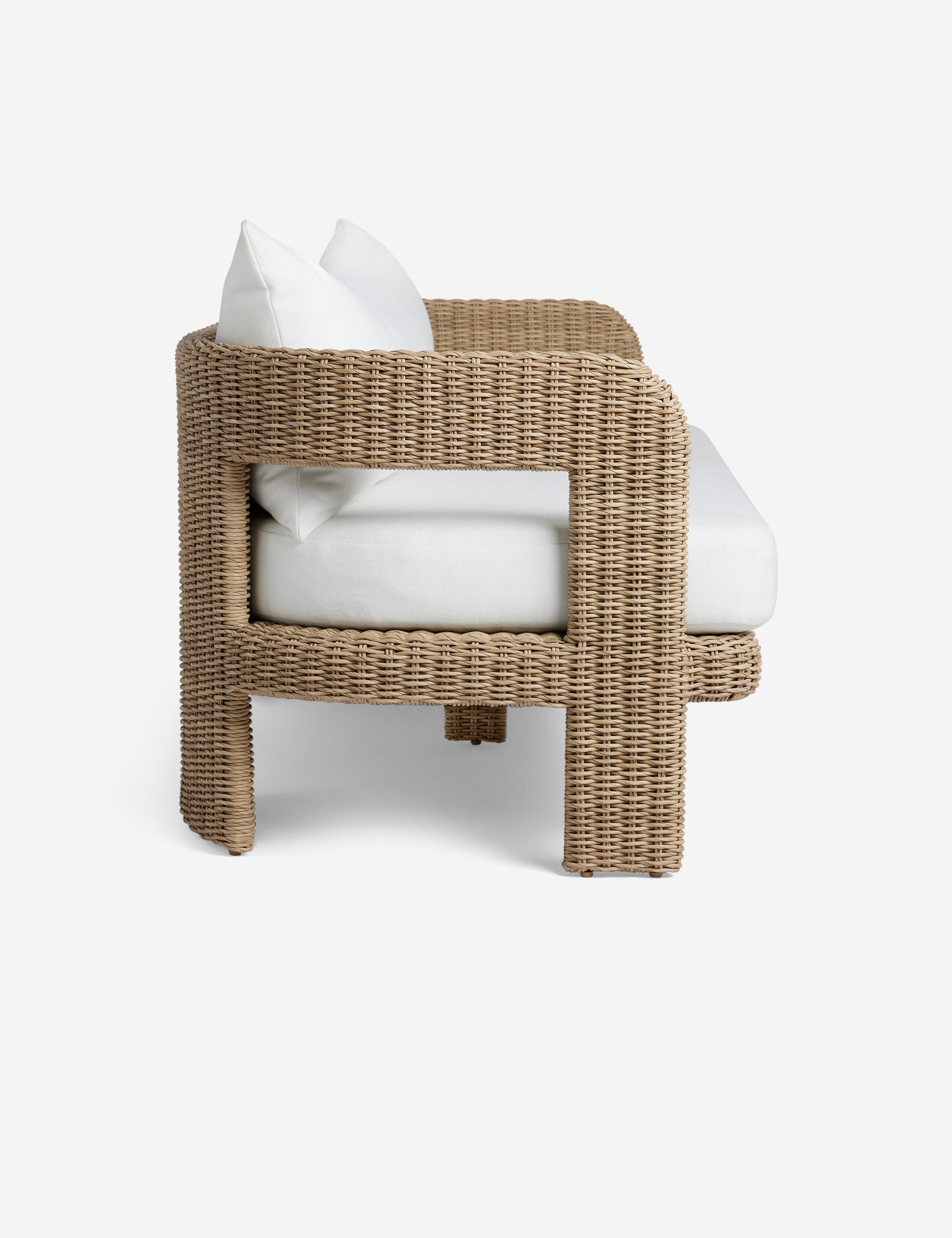 Side profile of the Hadler modern sculptural open frame wicker outdoor sofa.