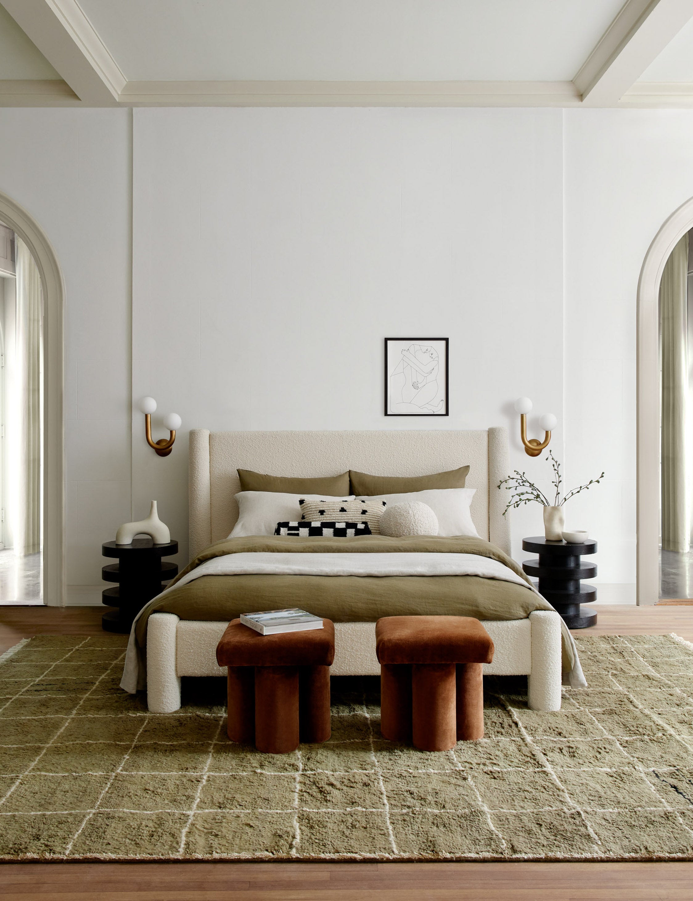 Khaki green Irregular Grid Rug by Sarah Sherman Samuel lays under a boucle framed bed between two circular nightstands