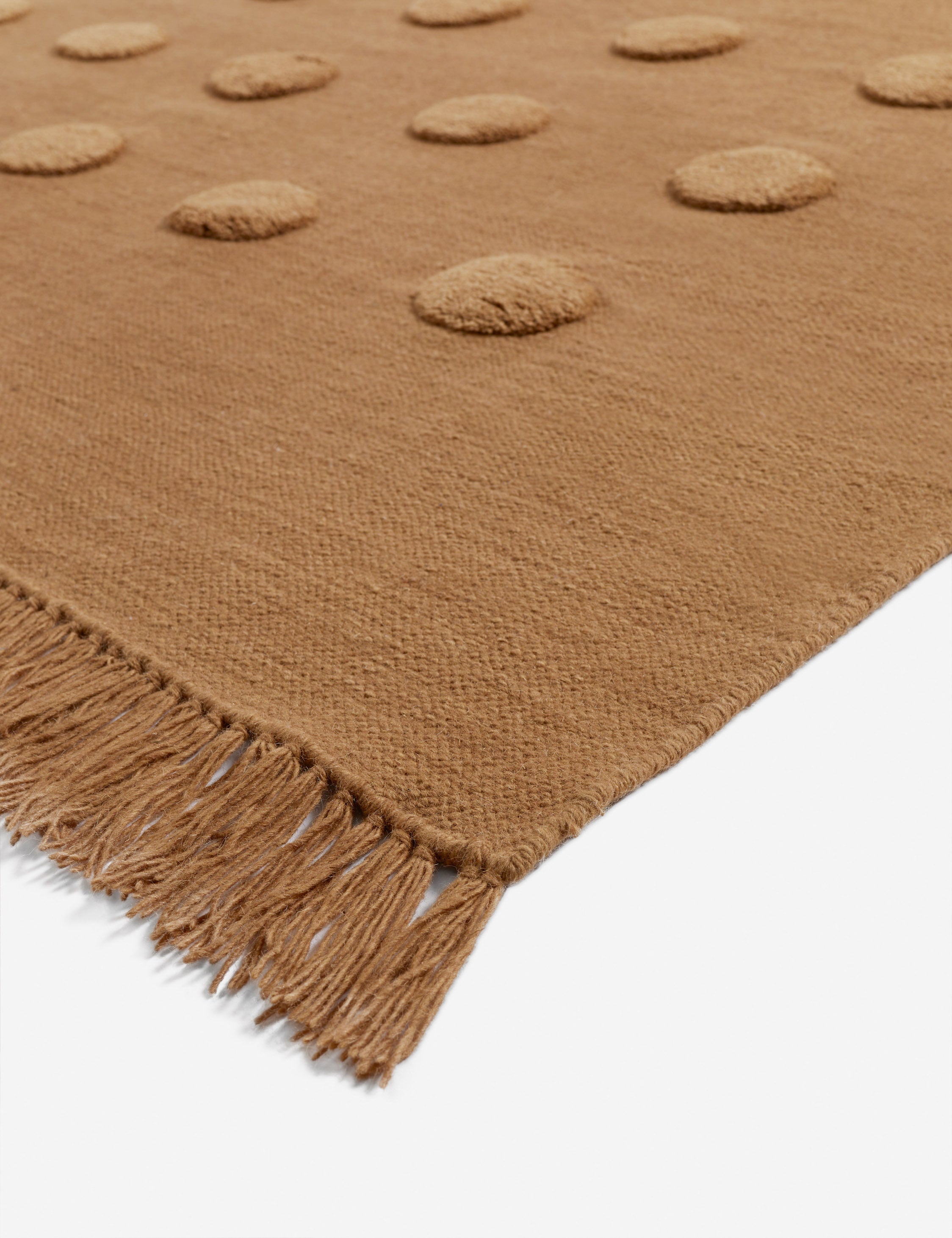 Corner of the Kohta high-low pile dot design wool area rug in camel