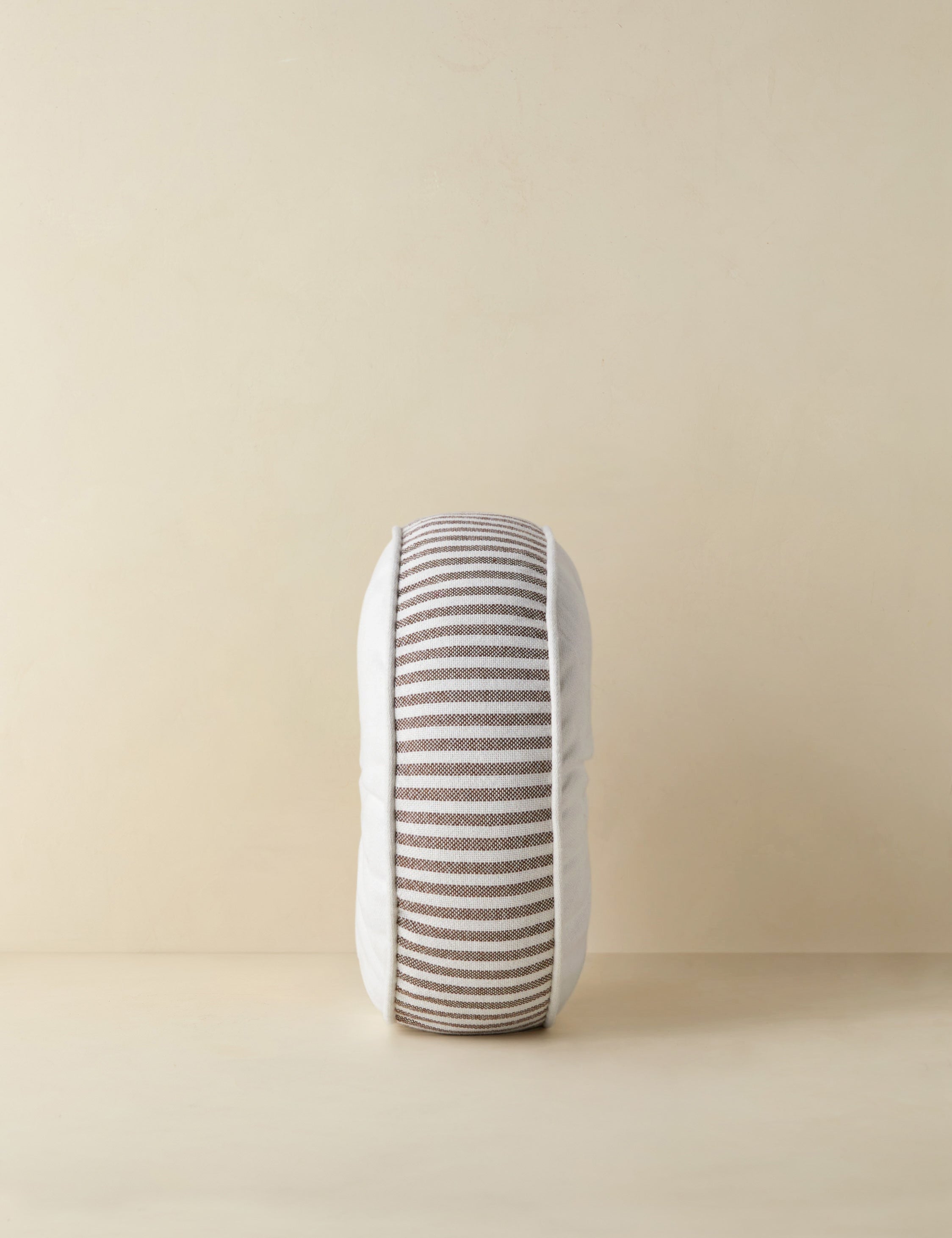 Side profile of the Littu Indoor / Outdoor Striped Disc Pillow by Sarah Sherman Samuel in Brown