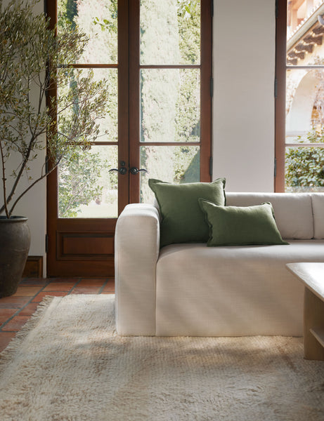 #color::olive #size::lumbar #fill type::with-feather-down-insert #fill type::pillow-cover-only | The arlo Olive green flax linen pillow in its lumber and square sizes sit together on a natural linen sofa