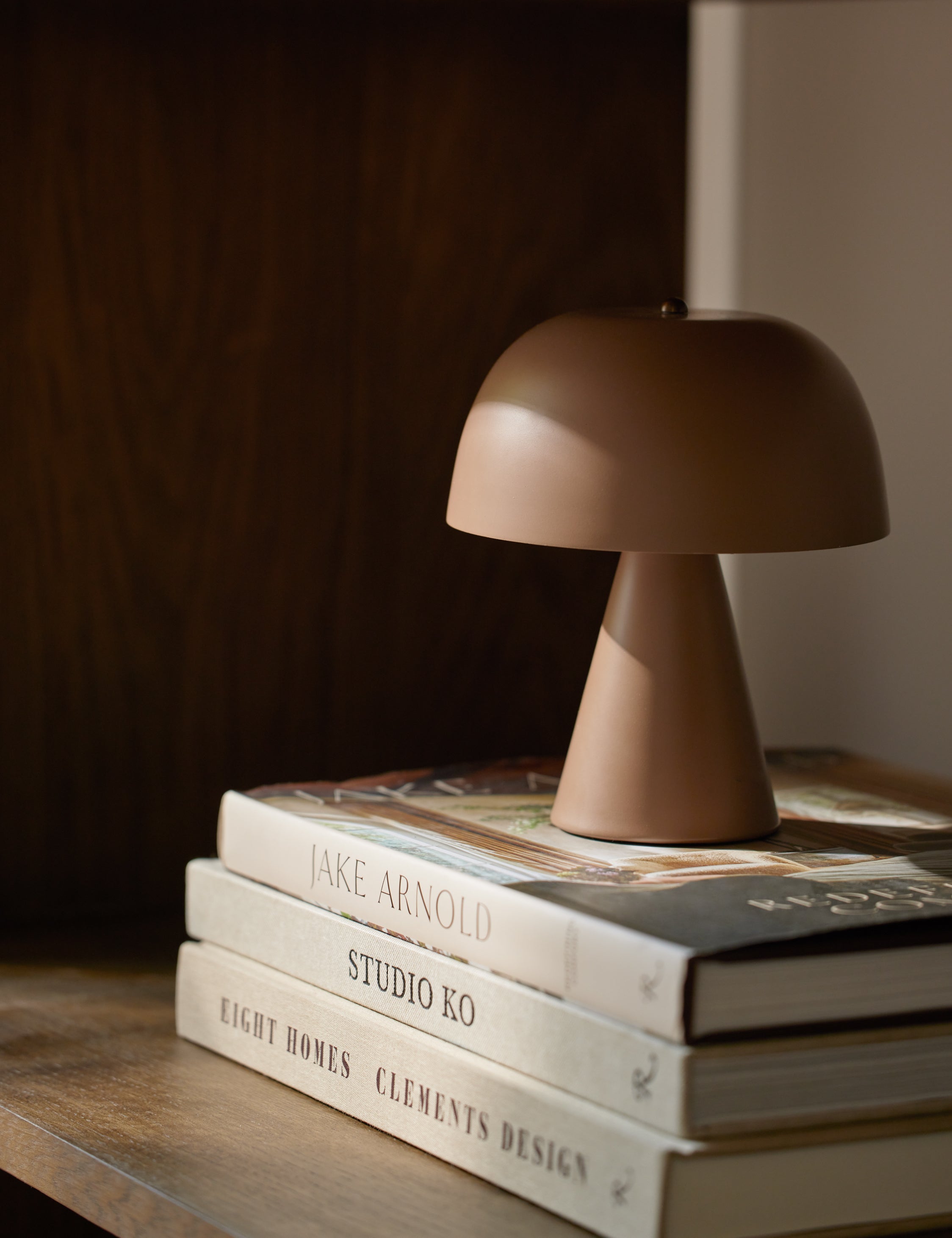 Monochromatic Wembley Cordless Mini Table Lamp styled on top of a stack of books