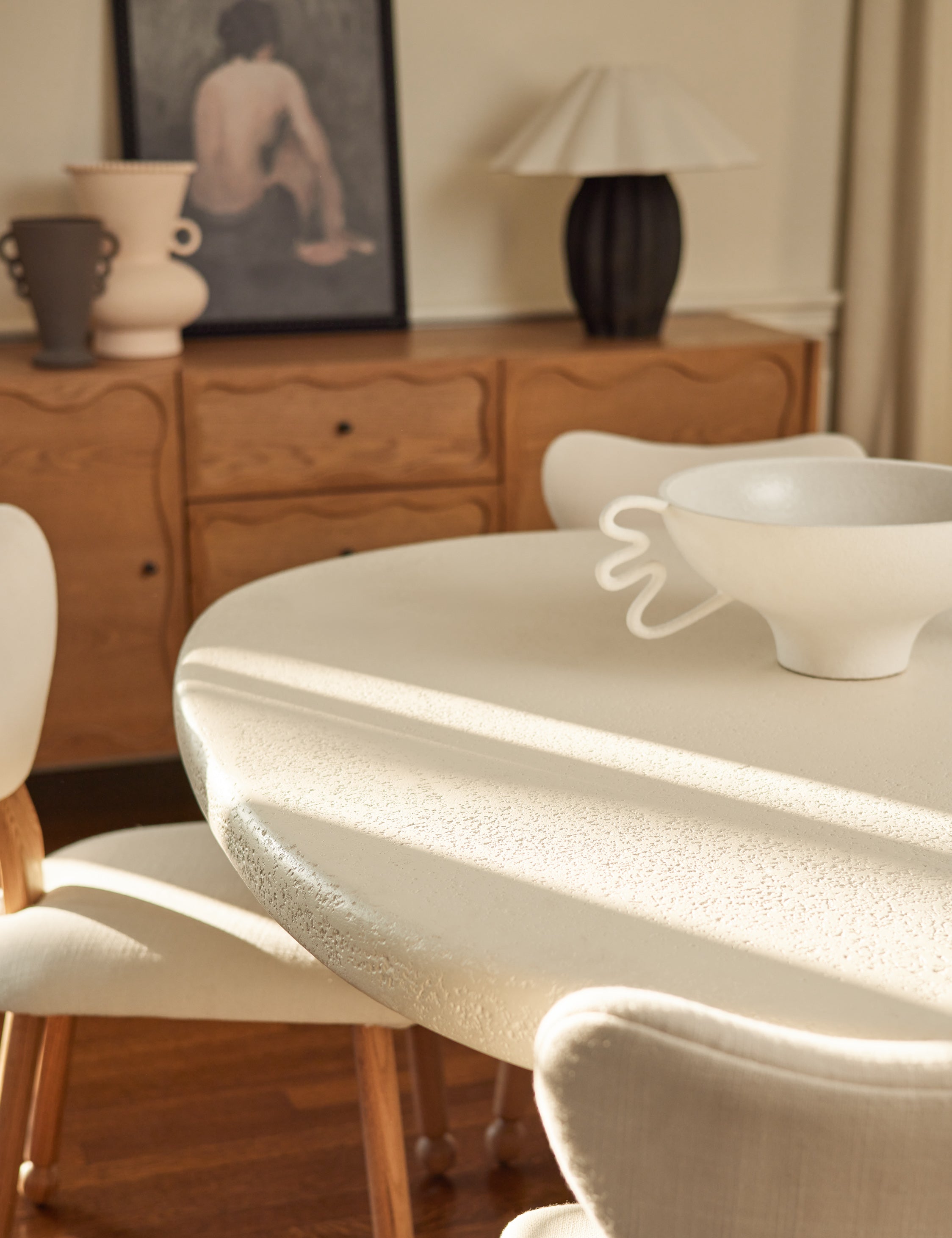 Close up view of the Hannu modern round fibercement dining table by Aimee Song in a dining room