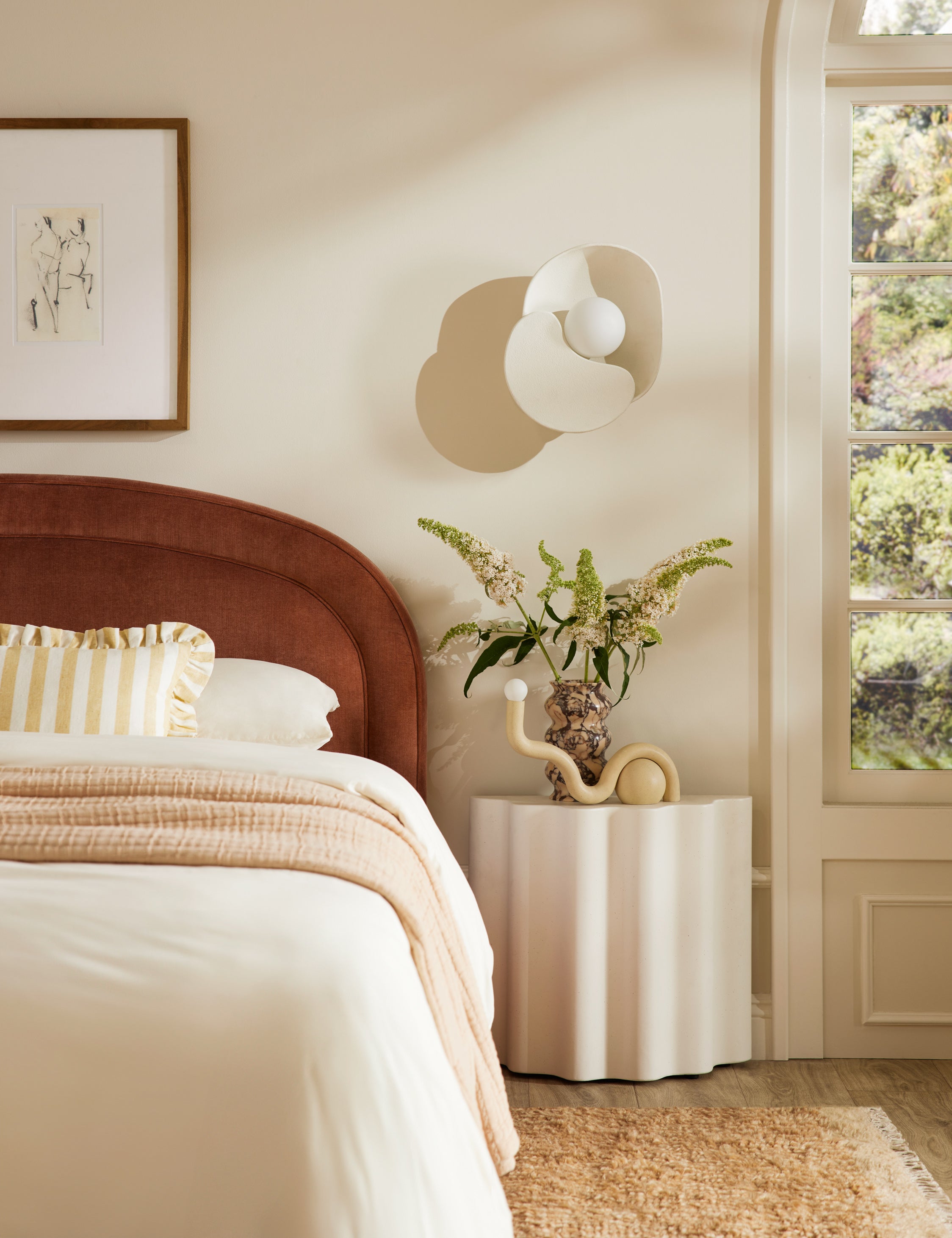 Noor sculptural, wavy table lamp styled on a bedside table