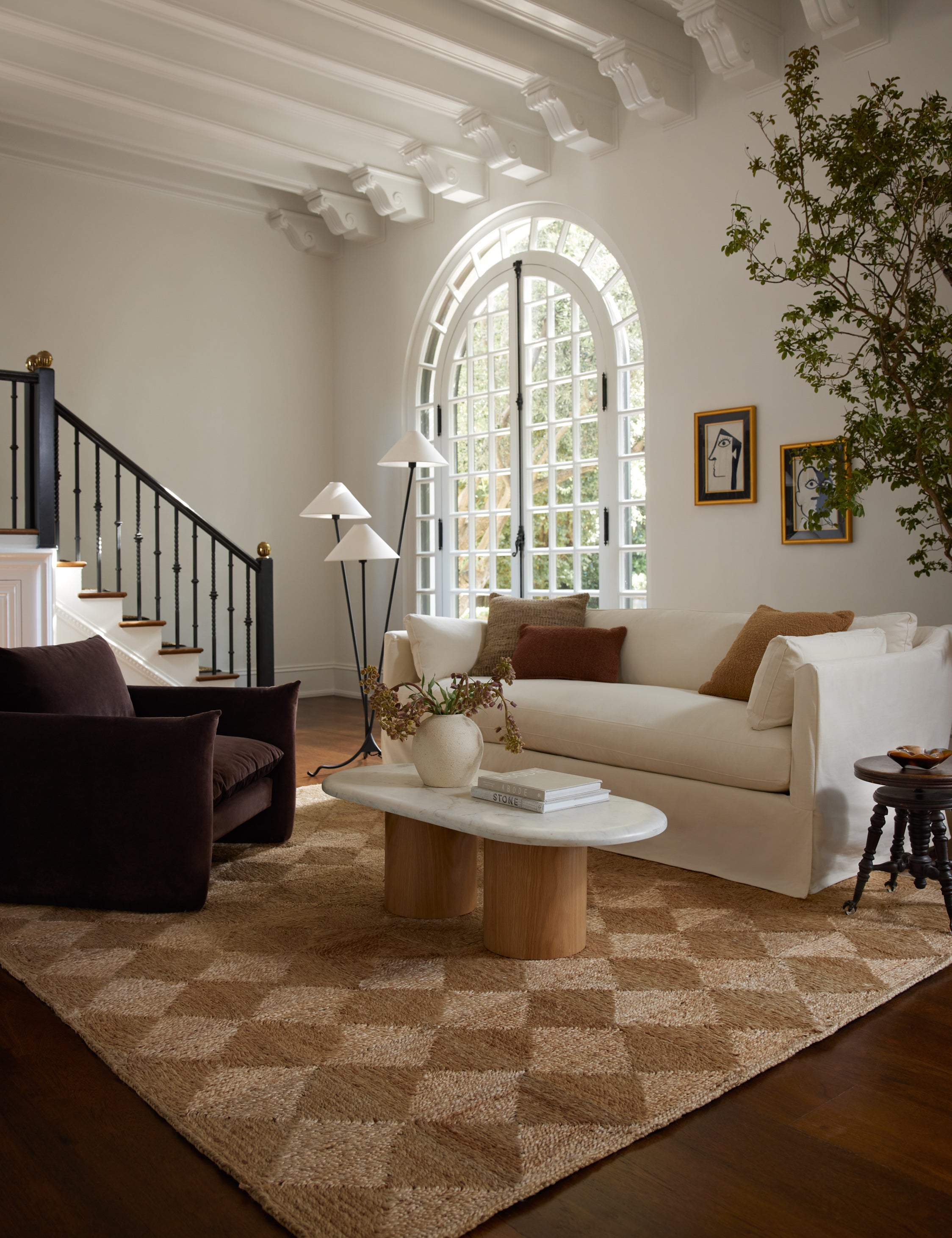The Havenhurst Rug lays in a brown-toned living room under a brown velvet accent chair and ivory linen sofa