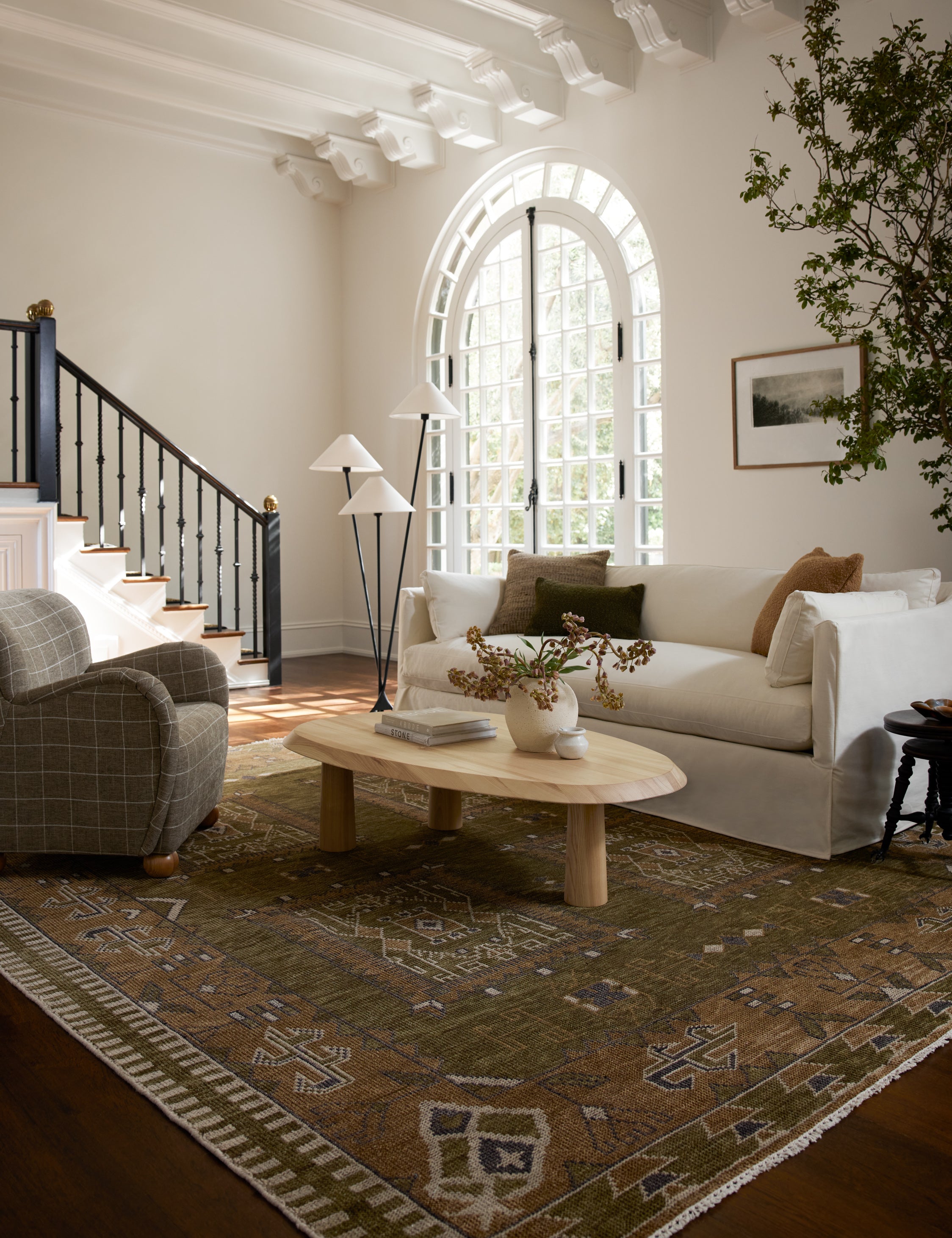 Living room featuring a white sofa, grid print upholstered accent chair and Rodolfo organic oval natural wood coffee table