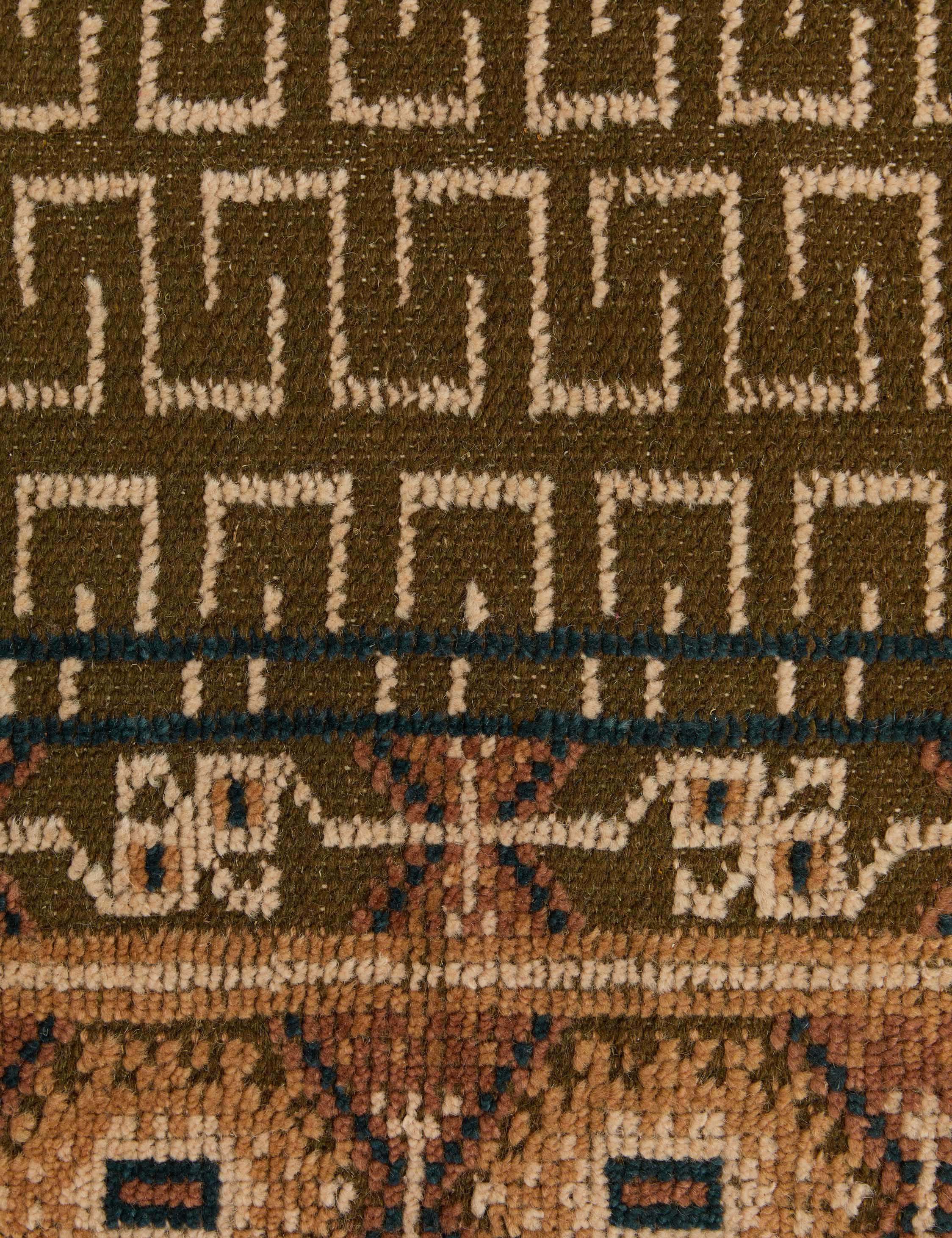 Close up of the pattern of the Manca traditional geometric motif hand-knotted wool rug.