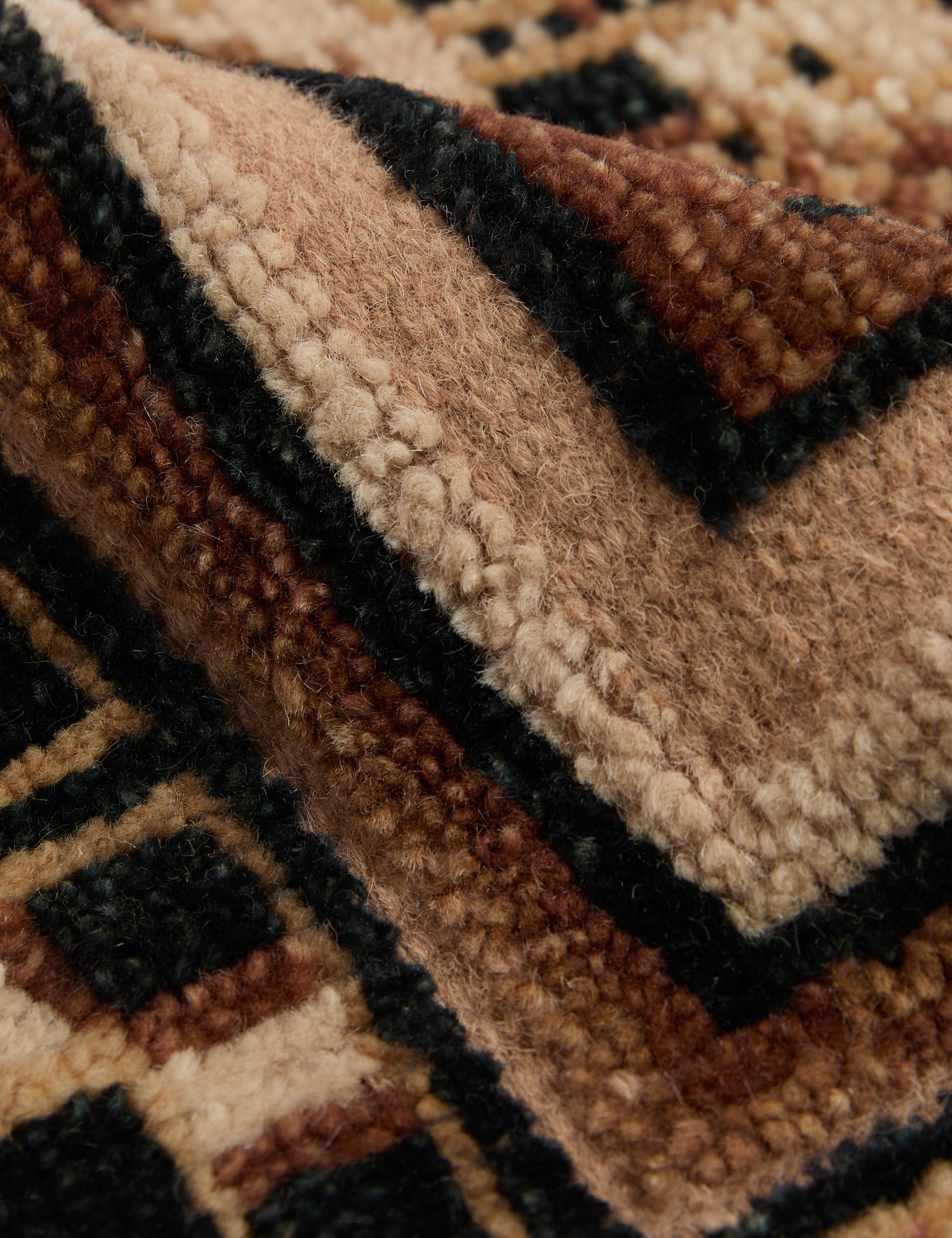 Close up of the Ovidi heritage motif hand-knotted wool rug.