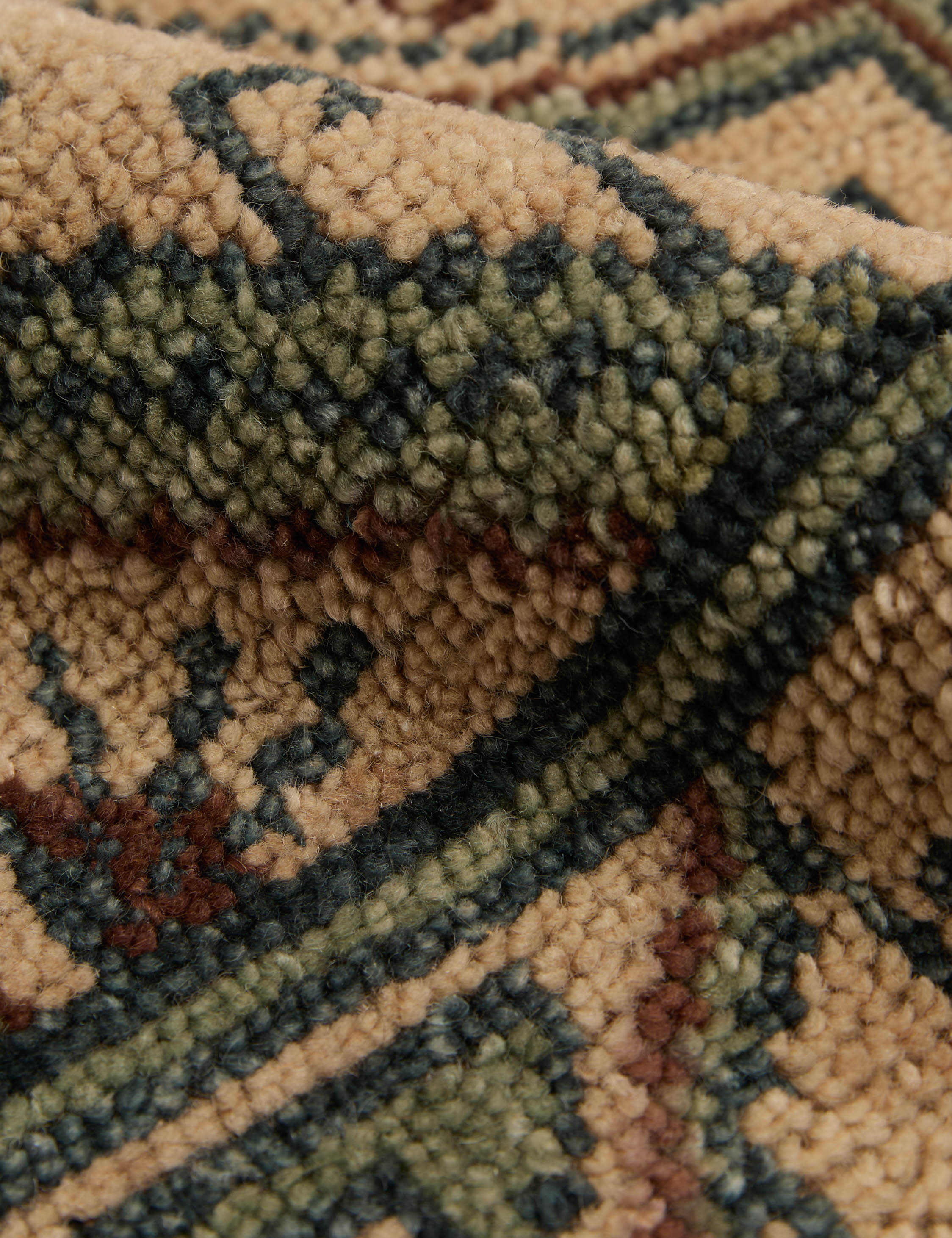 Close up of the texture of the Vishal geometric motif hand-knotted wool rug.