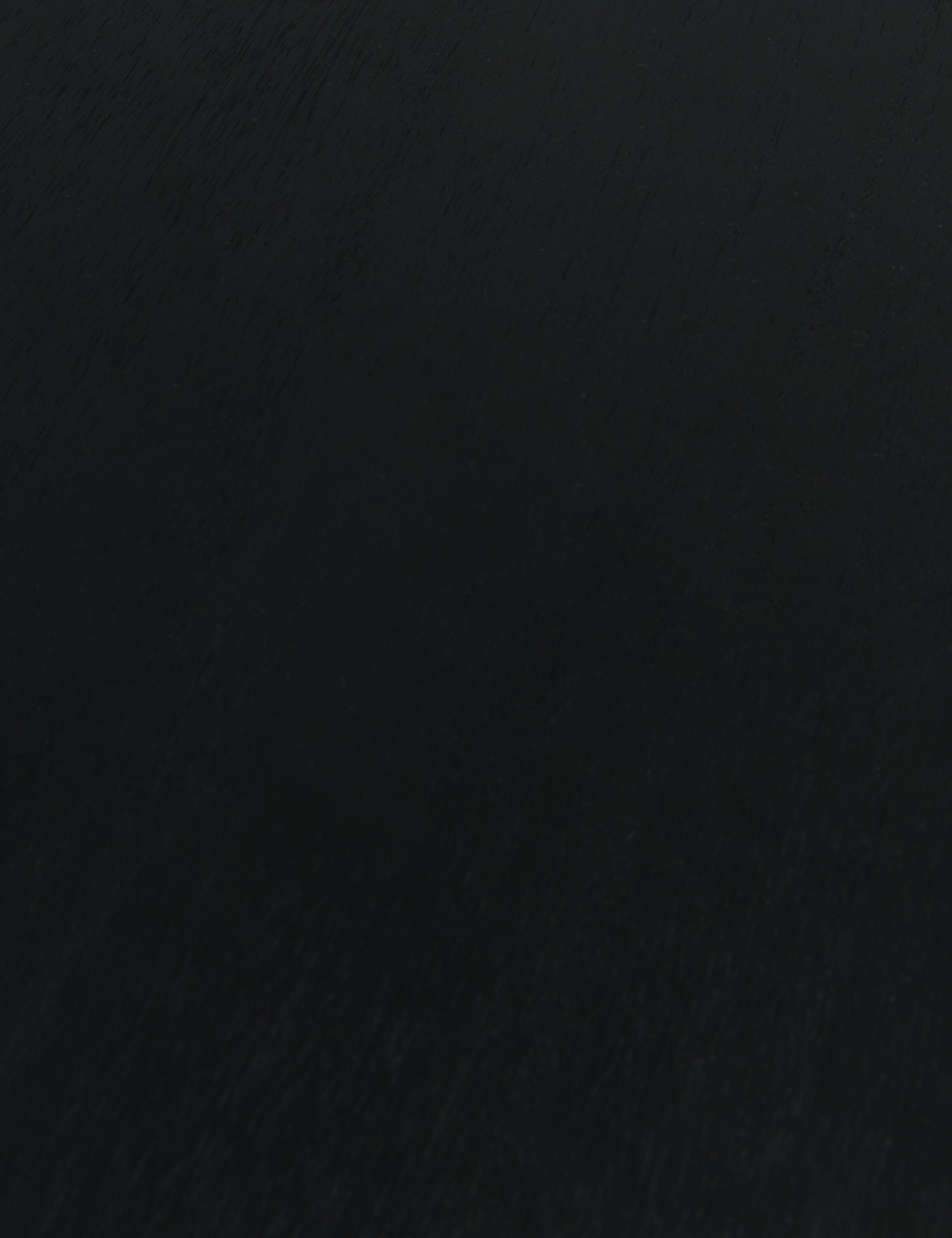 Close up of the wood grain of the Mojave round dining table in black.