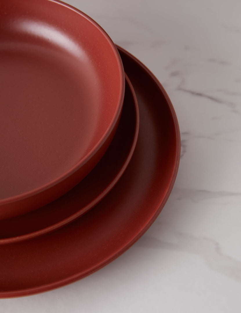 #color::cayenne #style::18-piece-set-with-pasta-bowl | A bowl and two plates that are part of the Cayenne red Pacifica Dinnerware (18-Piece Set) by Casafina stacked