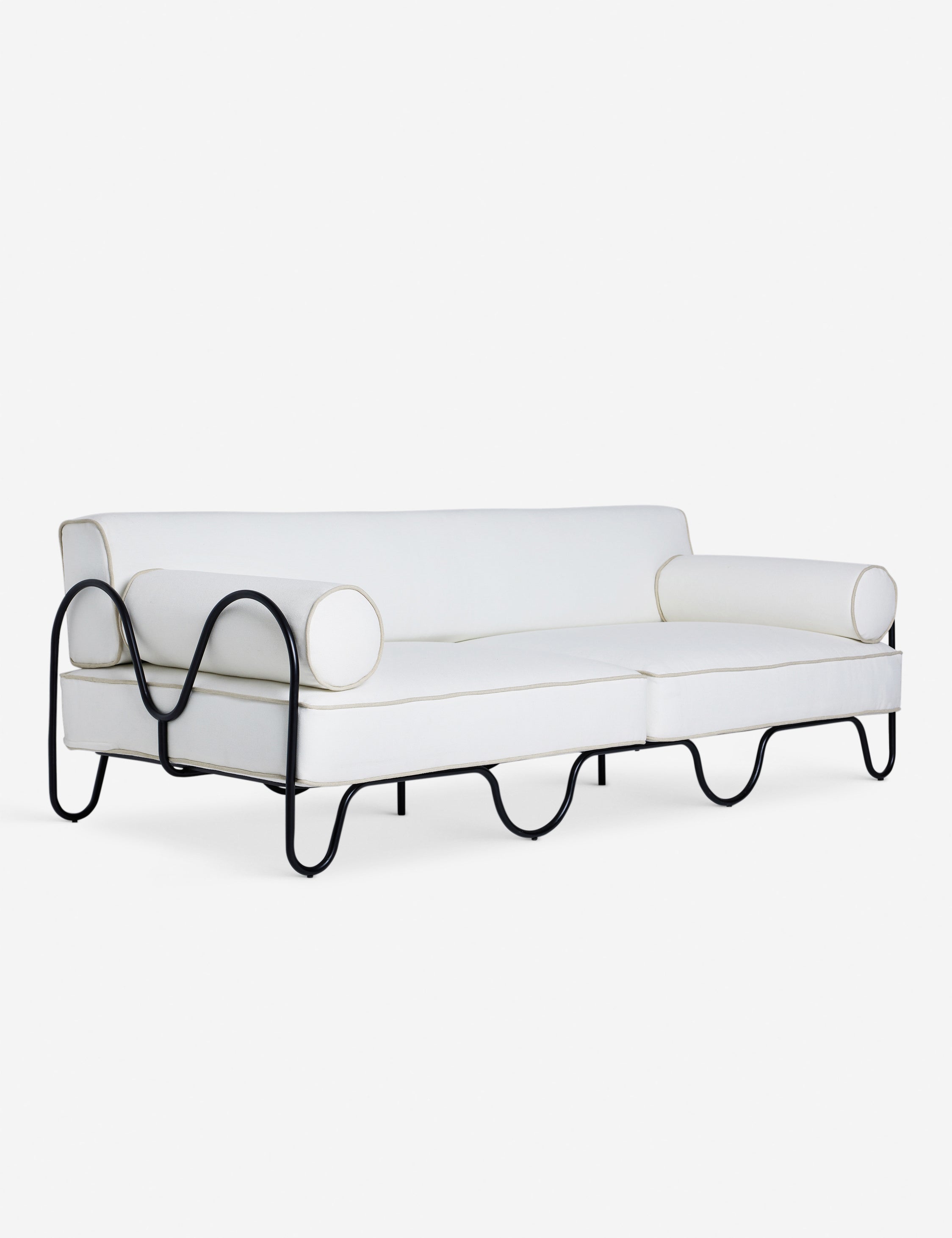 Angled view of the Peggy sculptural iron frame and white cushion outdoor sofa.