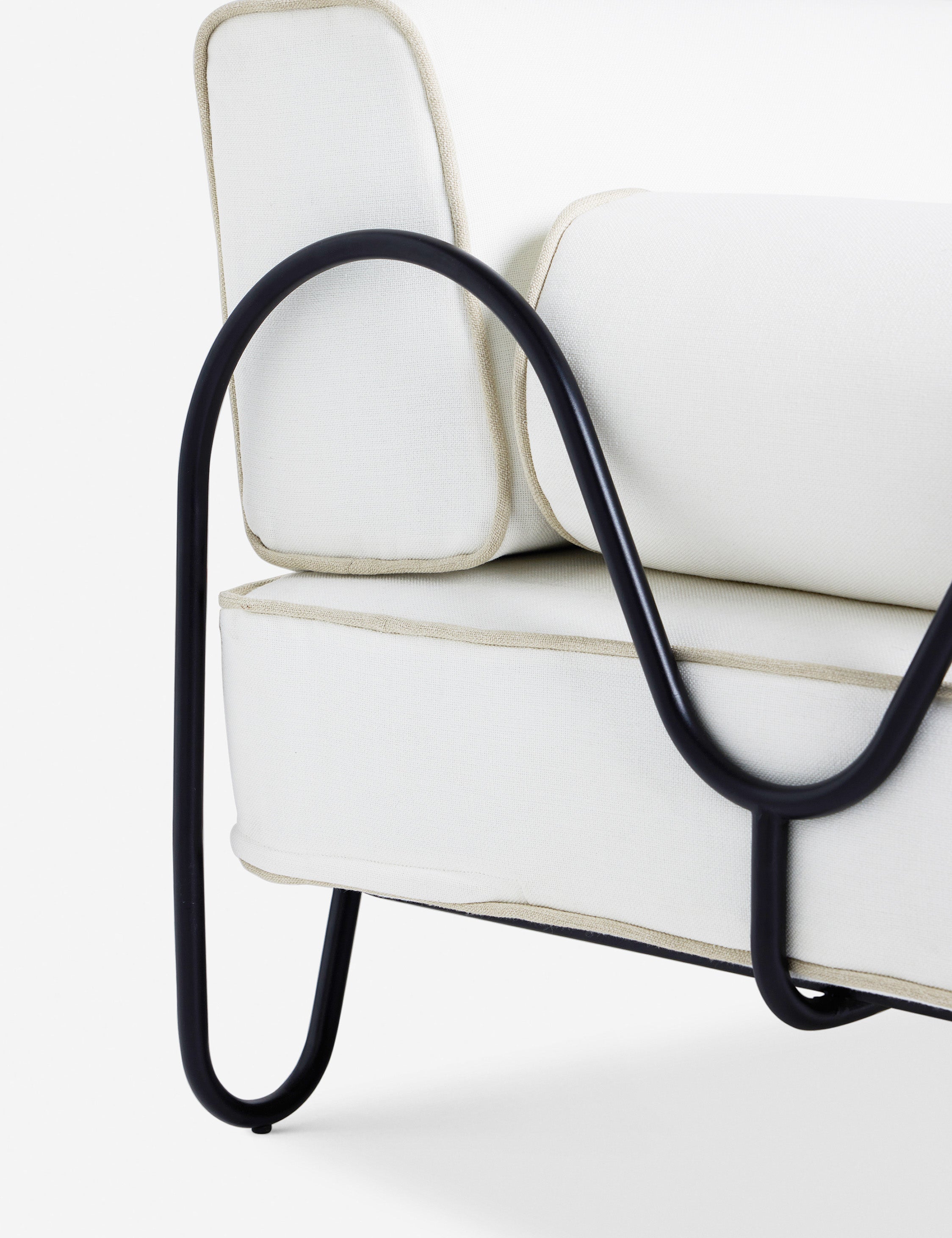 Close up of the Angled view of the Peggy sculptural iron frame and white cushion outdoor sofa.