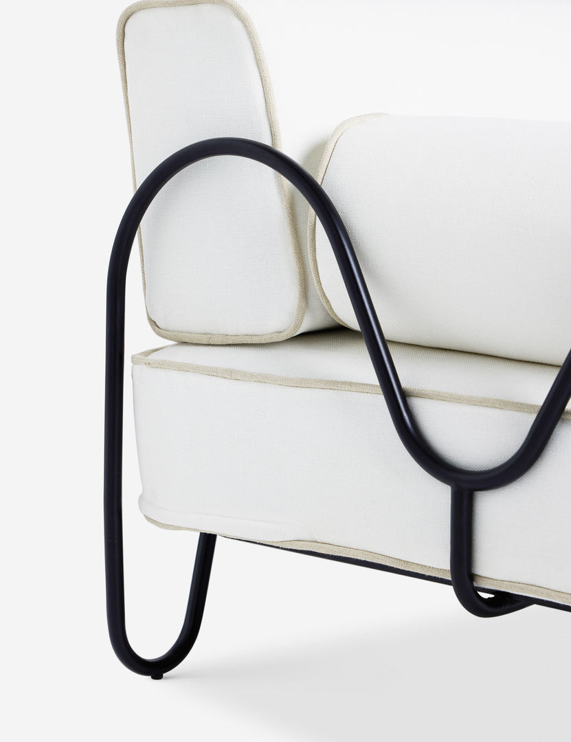 #color::ivory | Close up of the Angled view of the Peggy sculptural iron frame and white cushion outdoor sofa.
