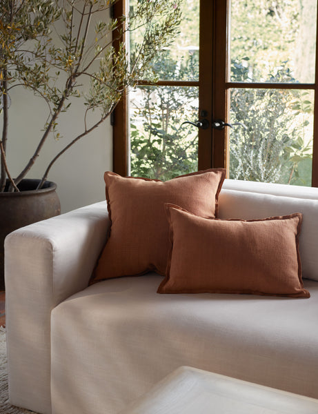 #color::burnt-orange #size::square #fill type::with-feather-down-insert #fill type::pillow-cover-only | The arlo Burnt Orange flax linen pillow in its lumber and square sizes sit together on a natural linen sofa