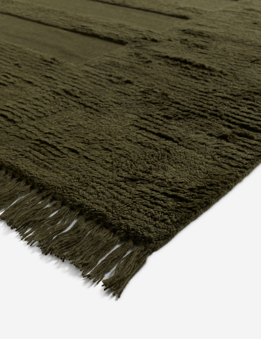 #color::moss #size::6--x-9- #size::8--x-10- #size::9--x-12- #size::10--x-14- #size::12--x-15- | Corner of the Raita subtle bar patter fringe area rug in moss green