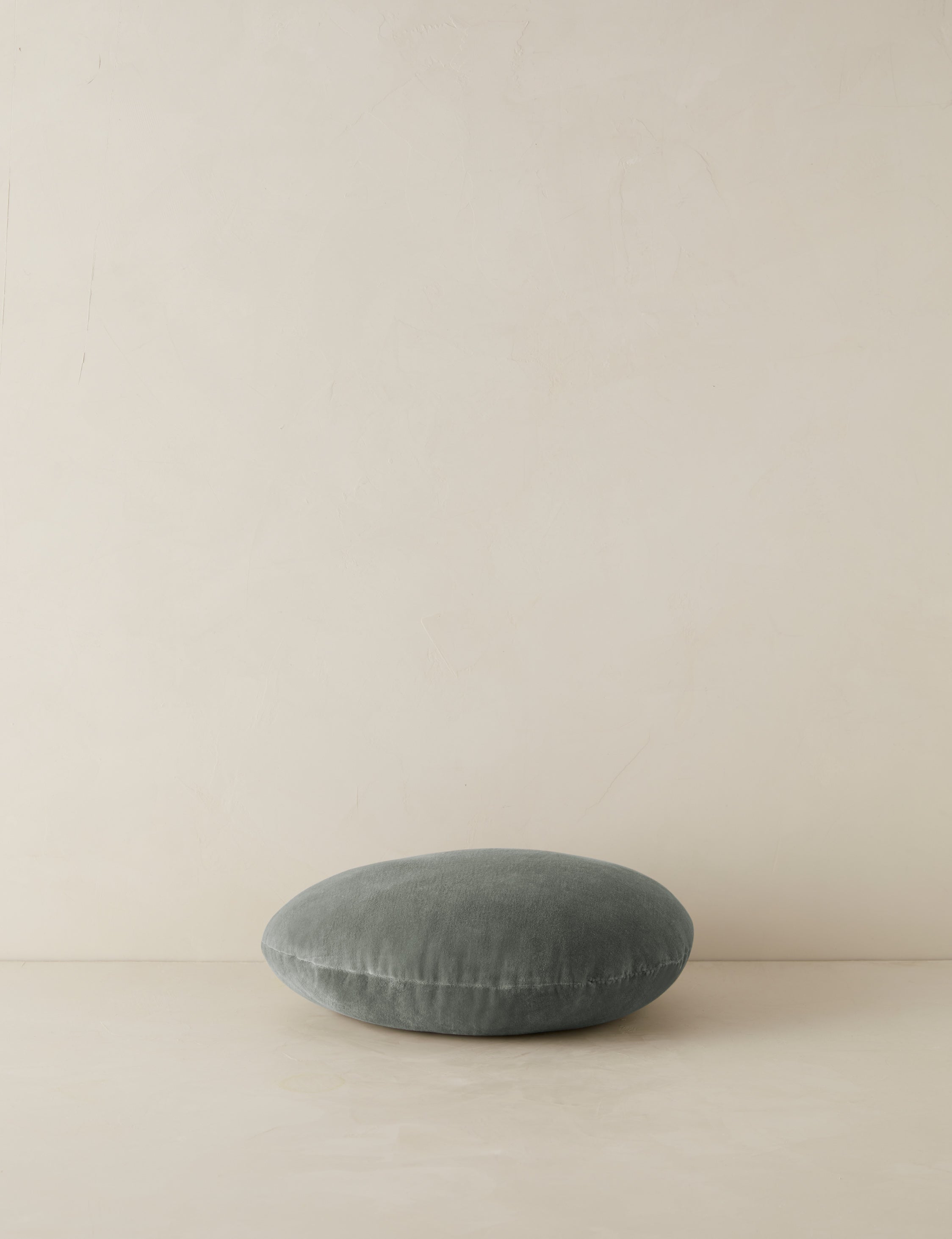 Velvet round accent pillow in lichen laying flat