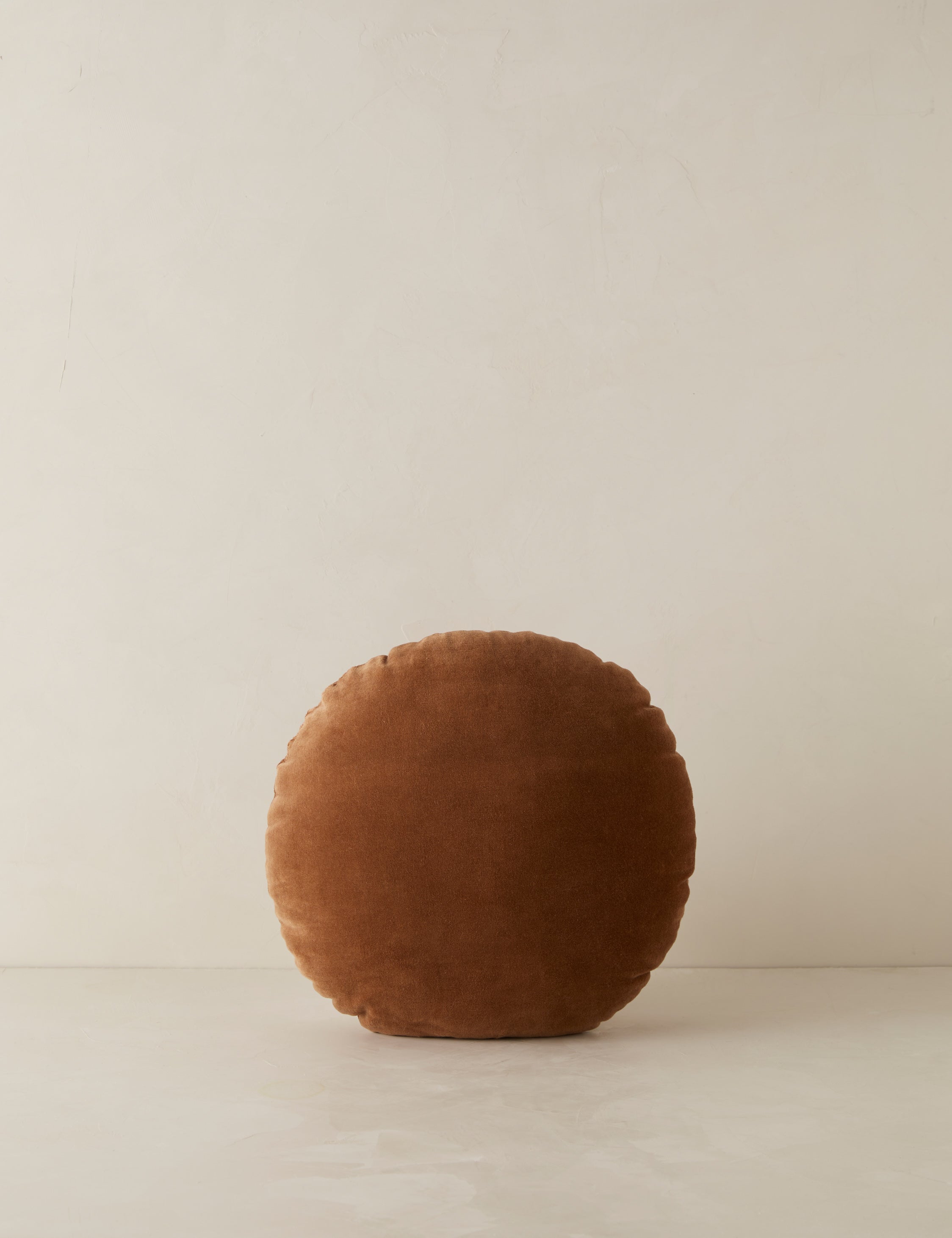 Velvet round accent pillow in rust umber