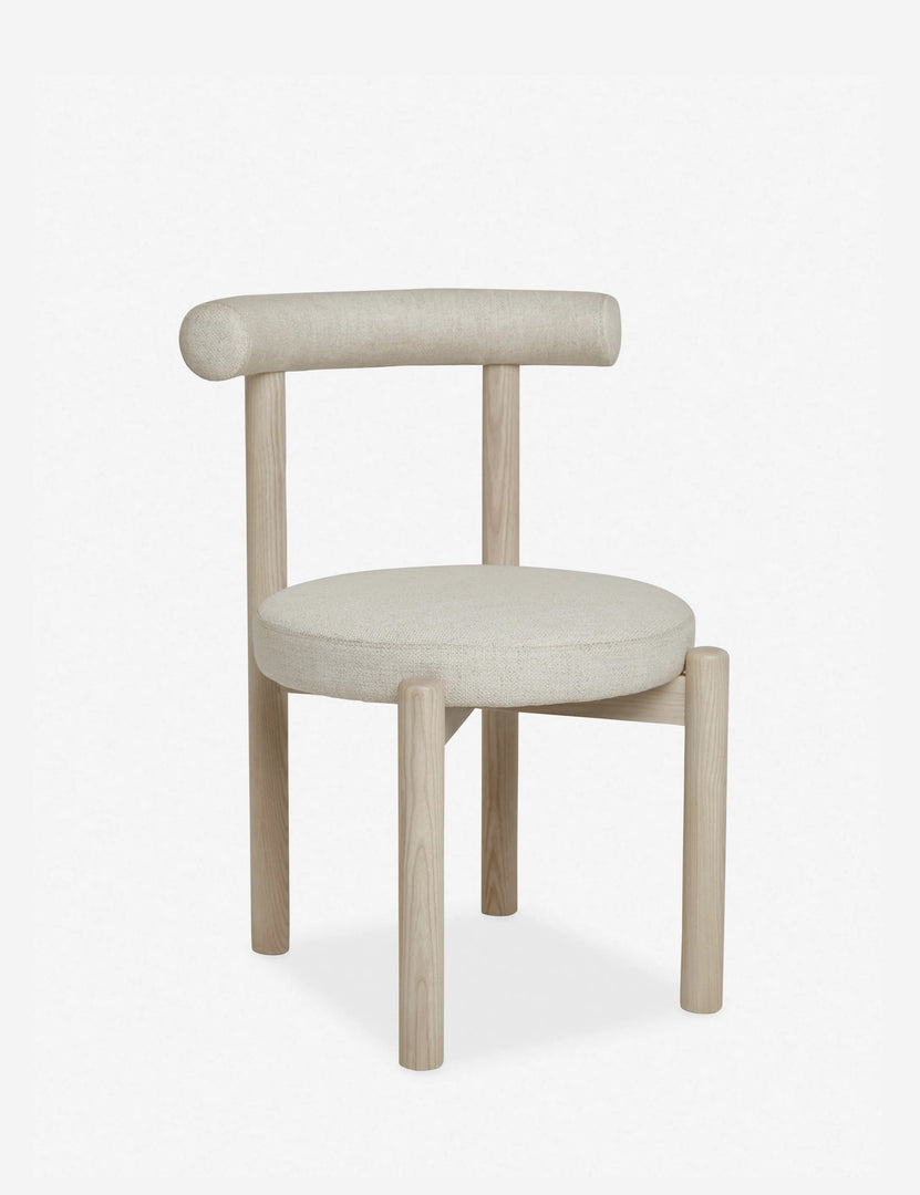 #color::whitewash | Angled left view of the Dame minimalist rounded open-back dining chair with ivory upholstered seat and ash wood frame