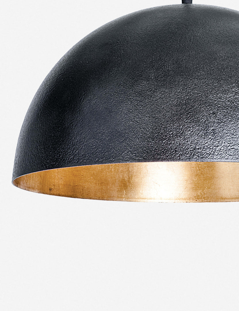 | Close-up of the left side of the Sigmund black pendant light with a gold-leaf interior by Regina Andrew