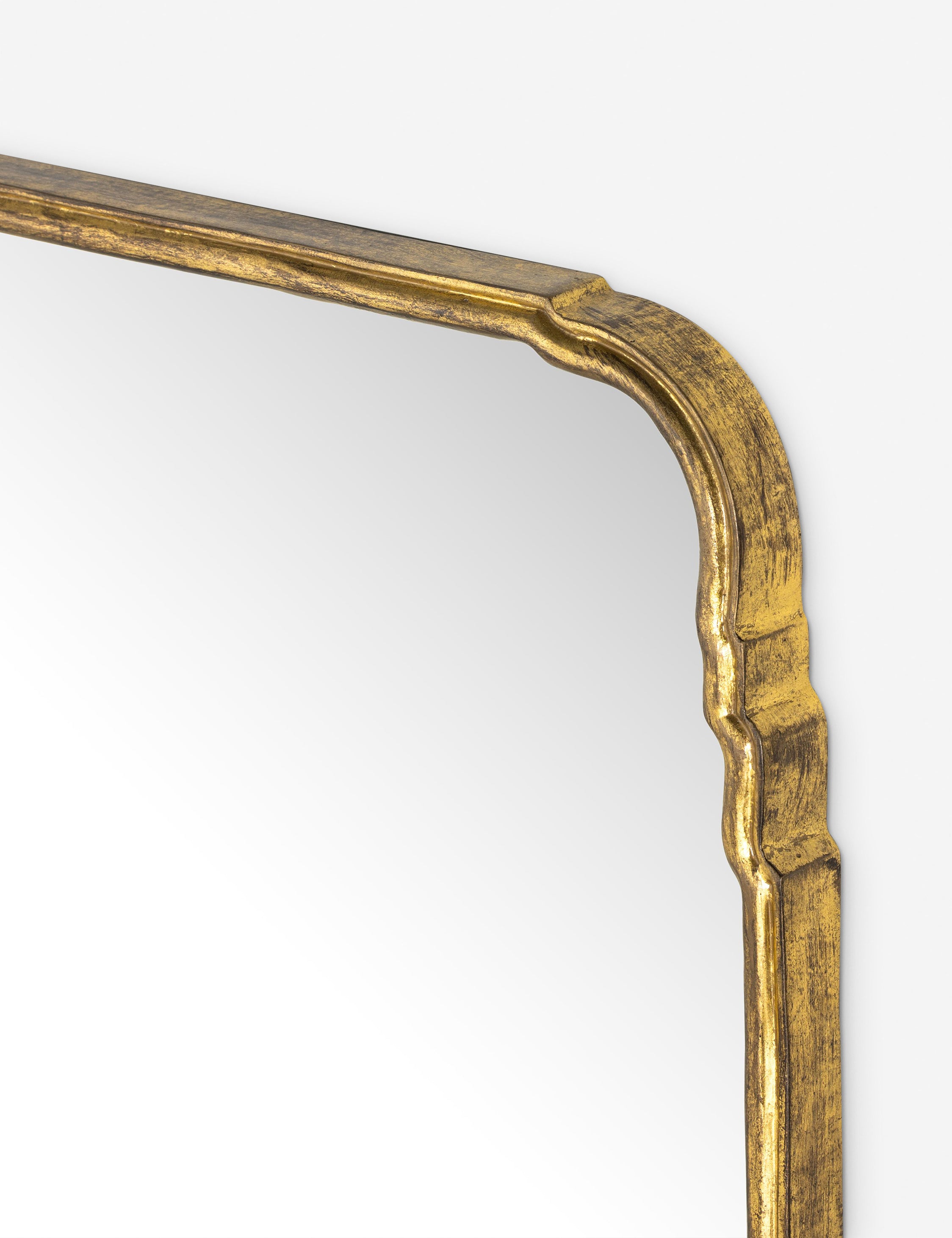 Close up of the top corner of the Teresa thin gold-leaf frame floor mirror.
