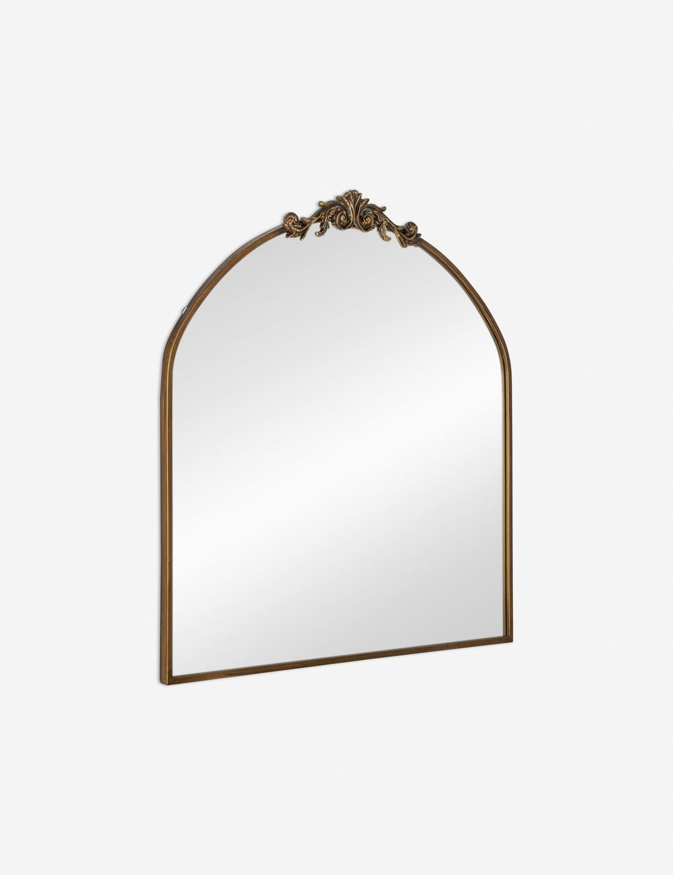Angled view of the Tulca arched gold mirror with flat bottom edge and traditional scroll detailing.