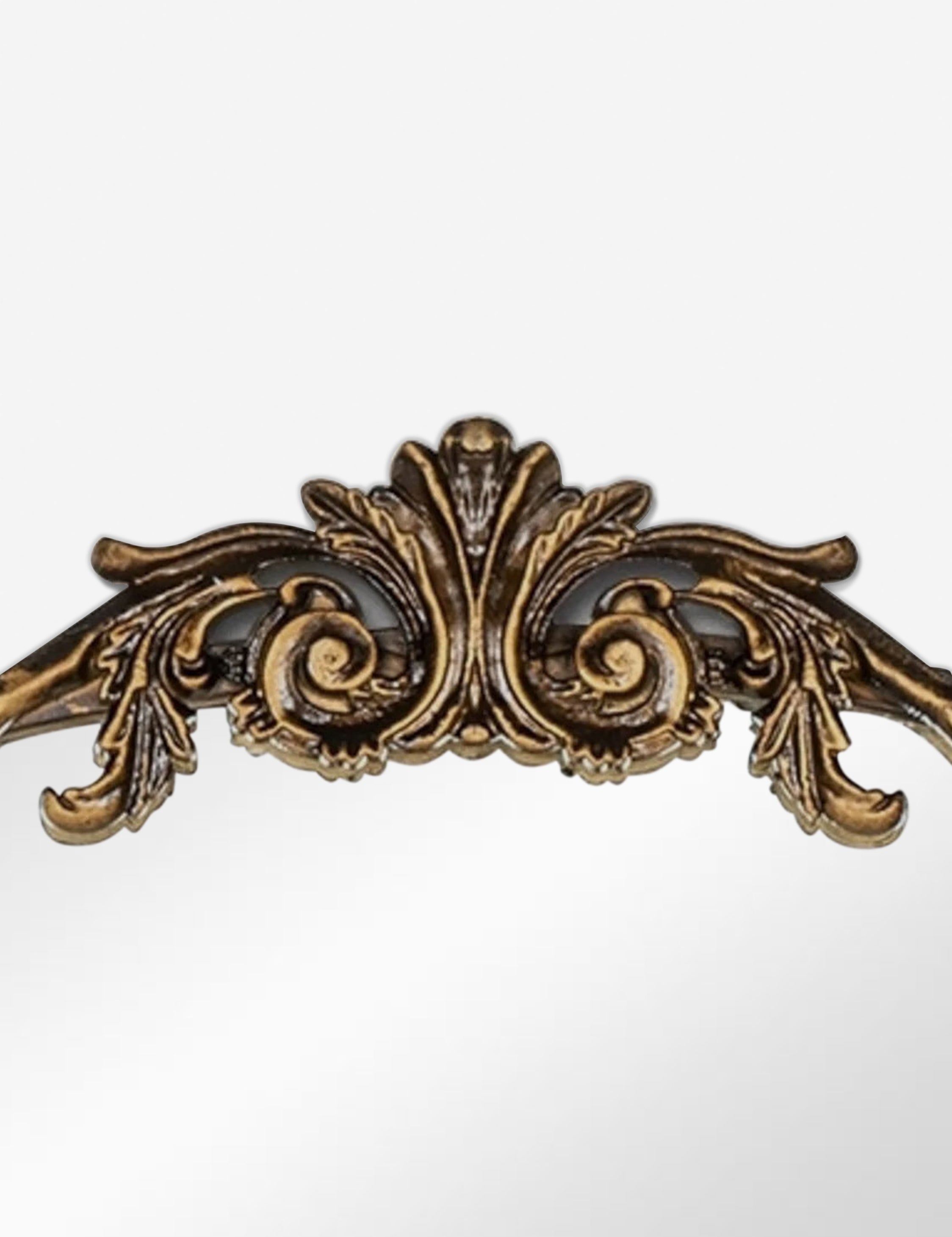 Detailed view of the traditional scroll detailing on the top of the Tulca arched gold mirror with flat bottom edge.
