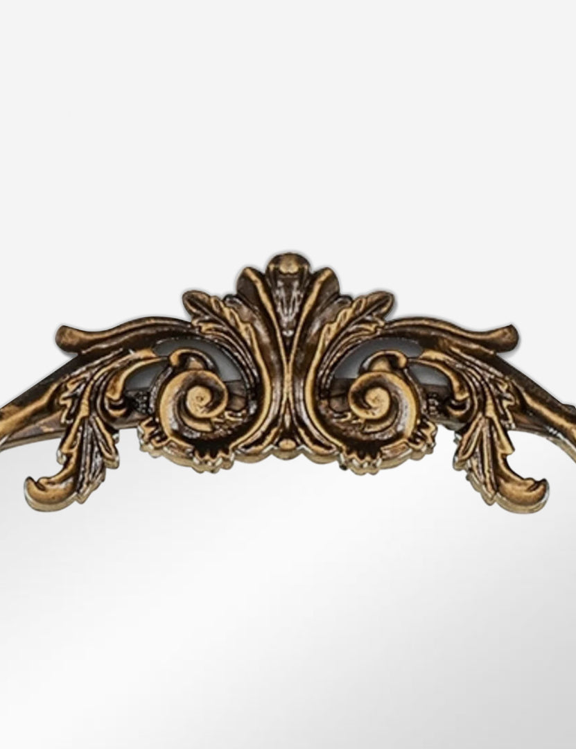 #color::gold | Detailed view of the traditional scroll detailing on the top of the Tulca arched gold mirror with flat bottom edge.
