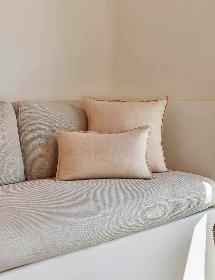 #color::blush #style::square #fill type::with-feather-down-insert #fill type::pillow-cover-only | The arlo Blush pink flax linen pillow in its lumber and square sizes sit together on a natural linen sofa