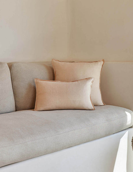 #color::blush #style::square #fill type::with-feather-down-insert #fill type::pillow-cover-only | The arlo Blush pink flax linen pillow in its lumber and square sizes sit together on a natural linen sofa