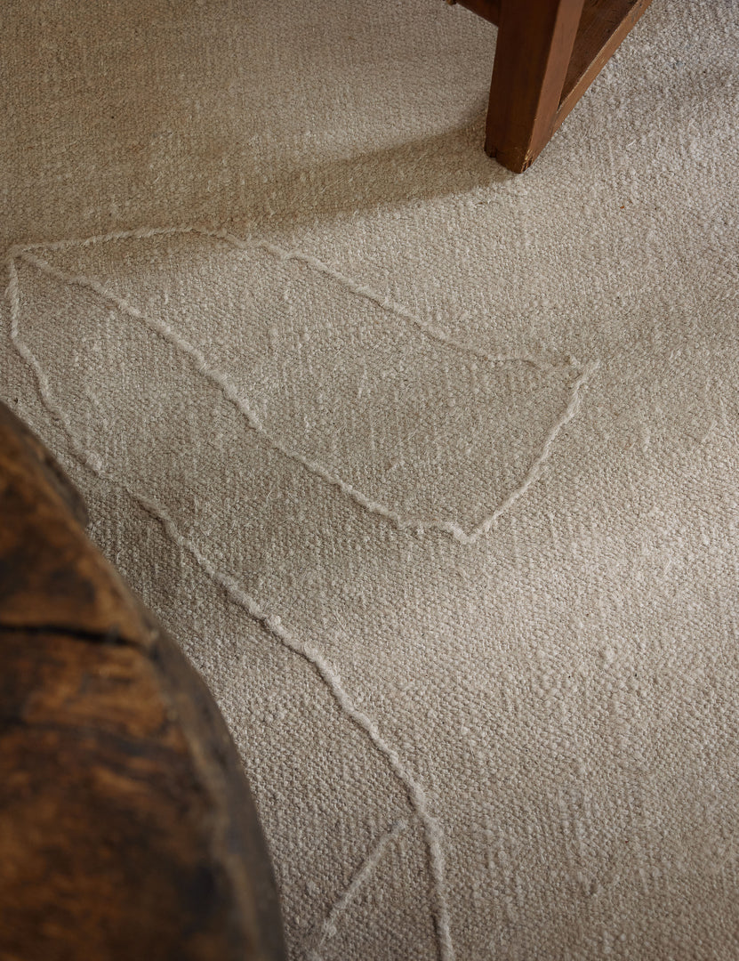 #size::2-6--x-8- #size::6--x-9- #size::8--x-10- #size::9--x-12- #size::10--x-14- #size::12--x-15- | Close up of the beachwood rug under a wooden coffee table and wooden framed accent chair