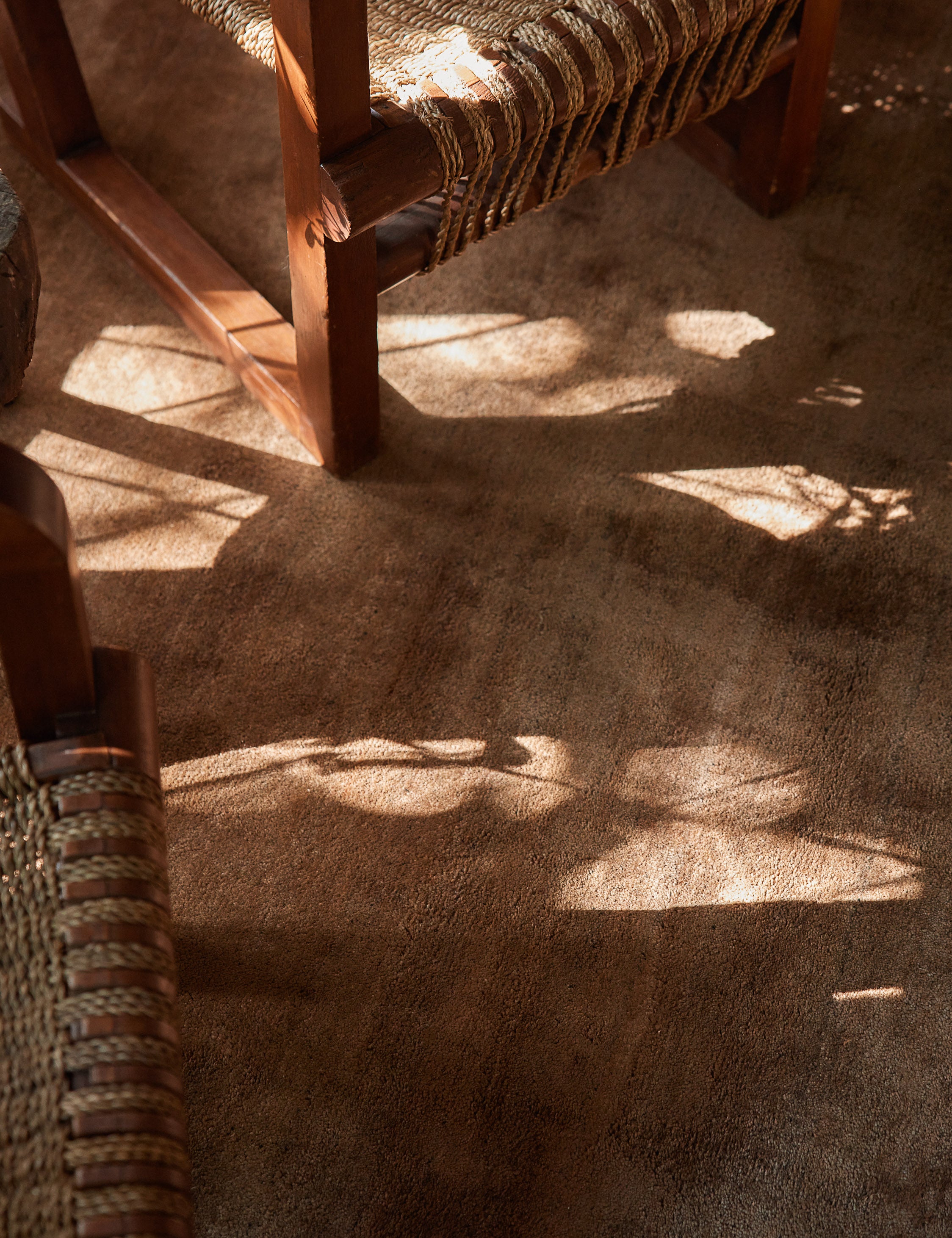 Close up of the Chiltern copper rug under two woven accent chairs