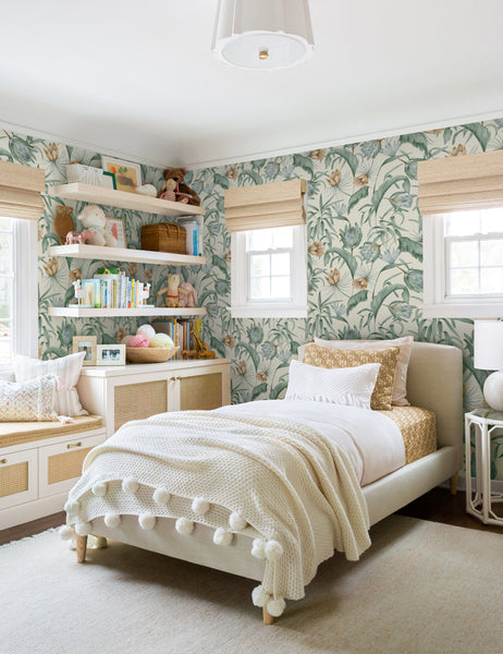 #color::green | Green-toned Tropical Wallpaper by Rylee + Cru is in a children's bedroom with a pom-pom throw blanket and a shelf lined with children's toys