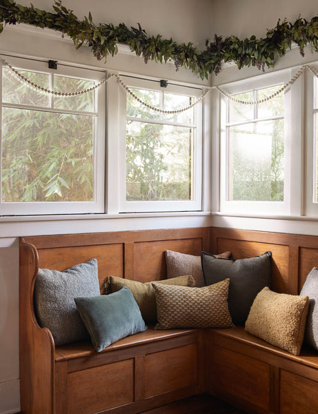 #color::conifer #style::square #fill type::with-feather-down-insert #fill type::pillow-cover-only | The arlo conifer gray pillow sits in a festive nook on a wooden corner bench