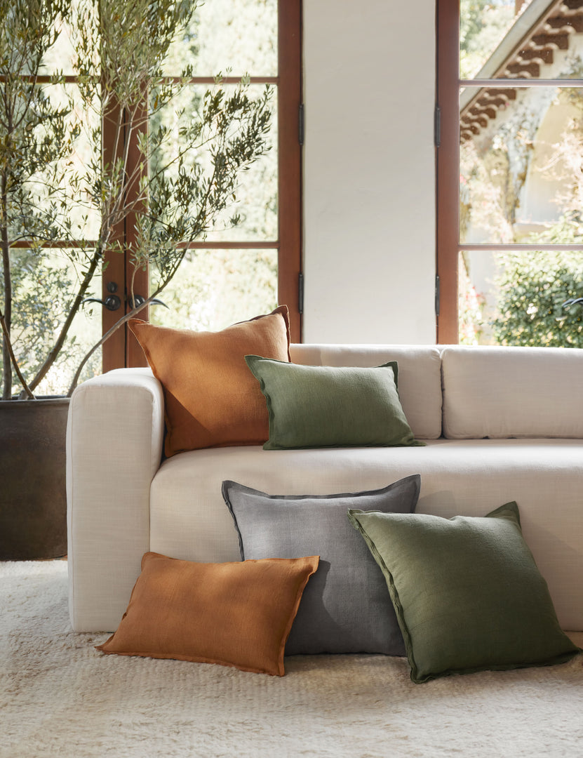 #color::dusty-blue #color::burnt-orange  #color::olive #fill type::with-feather-down-insert #fill type::pillow-cover-only | The dusty blue, burnt orange, and olive arlo linen pillows sit together on a plush ivory rug and a natural linen sofa