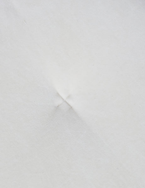 #color::ivory | Close up of the "X" stitch in the center of the velvet disc pillow by Sarah Sherman samuel