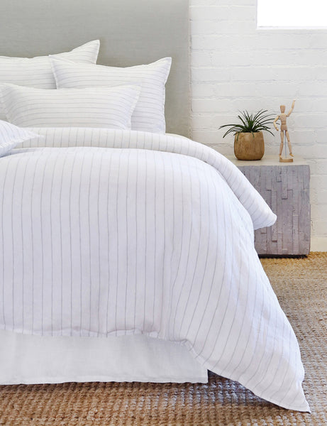#color::white-and-ocean #size::king #size::queen | The Blake white and ocean linen duvet by pom pom at Home lays atop a white linen framed bed in a bedroom with a jute rug and a cubical gray nightstand 