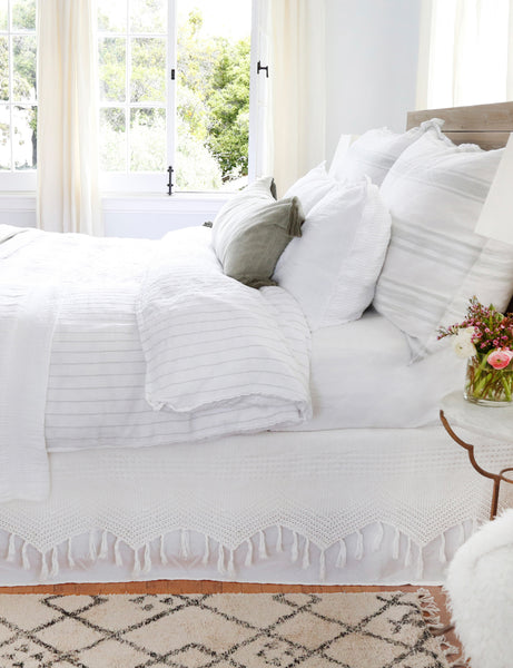 #color::white-and-ocean #size::king #size::queen | The Blake white and ocean linen duvet by pom pom at home lays atop a wooden framed bed in a bright bedroom with a plush patterned rug