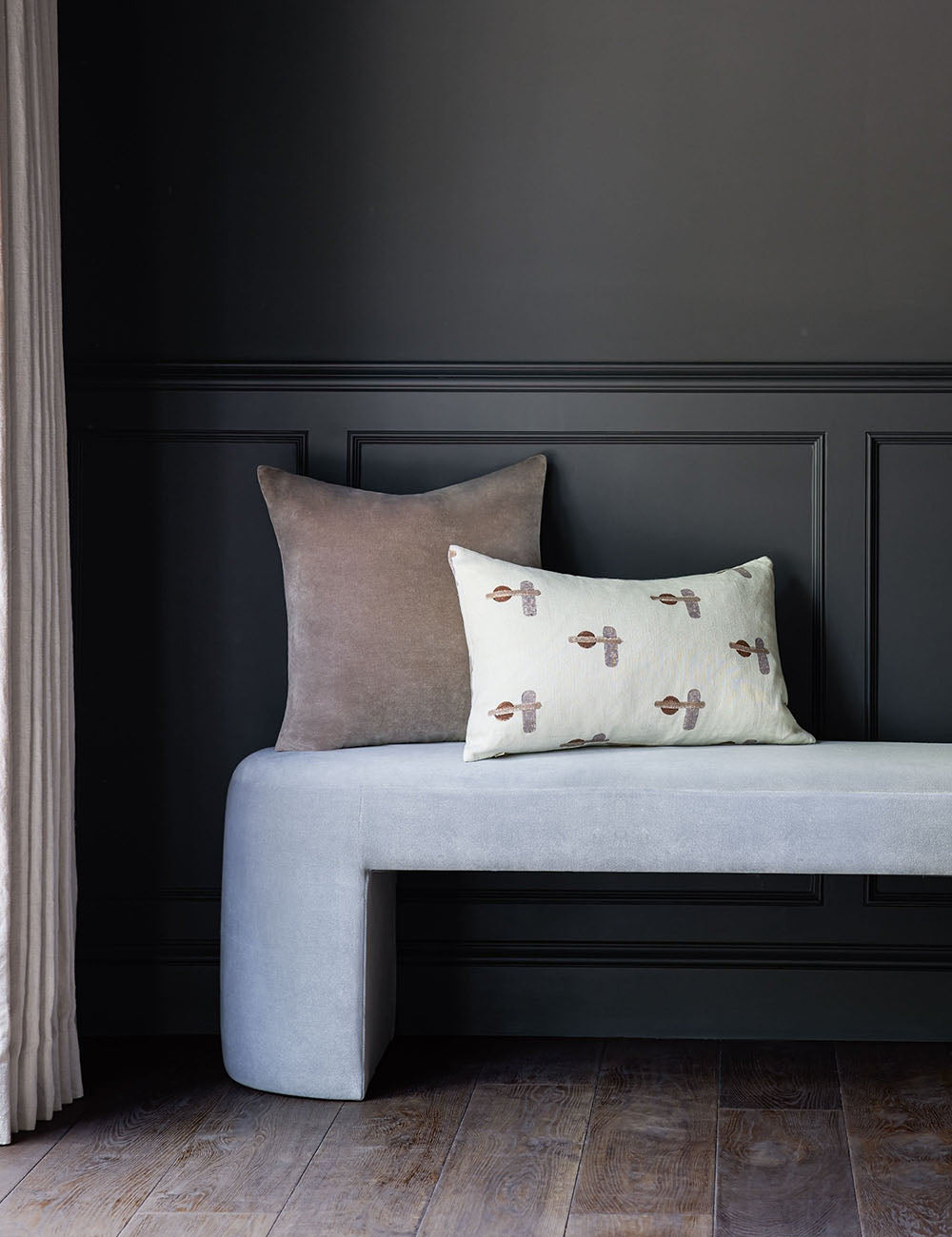 Charlotte warm gray square velvet pillow sits atop an ice blue velvet bench