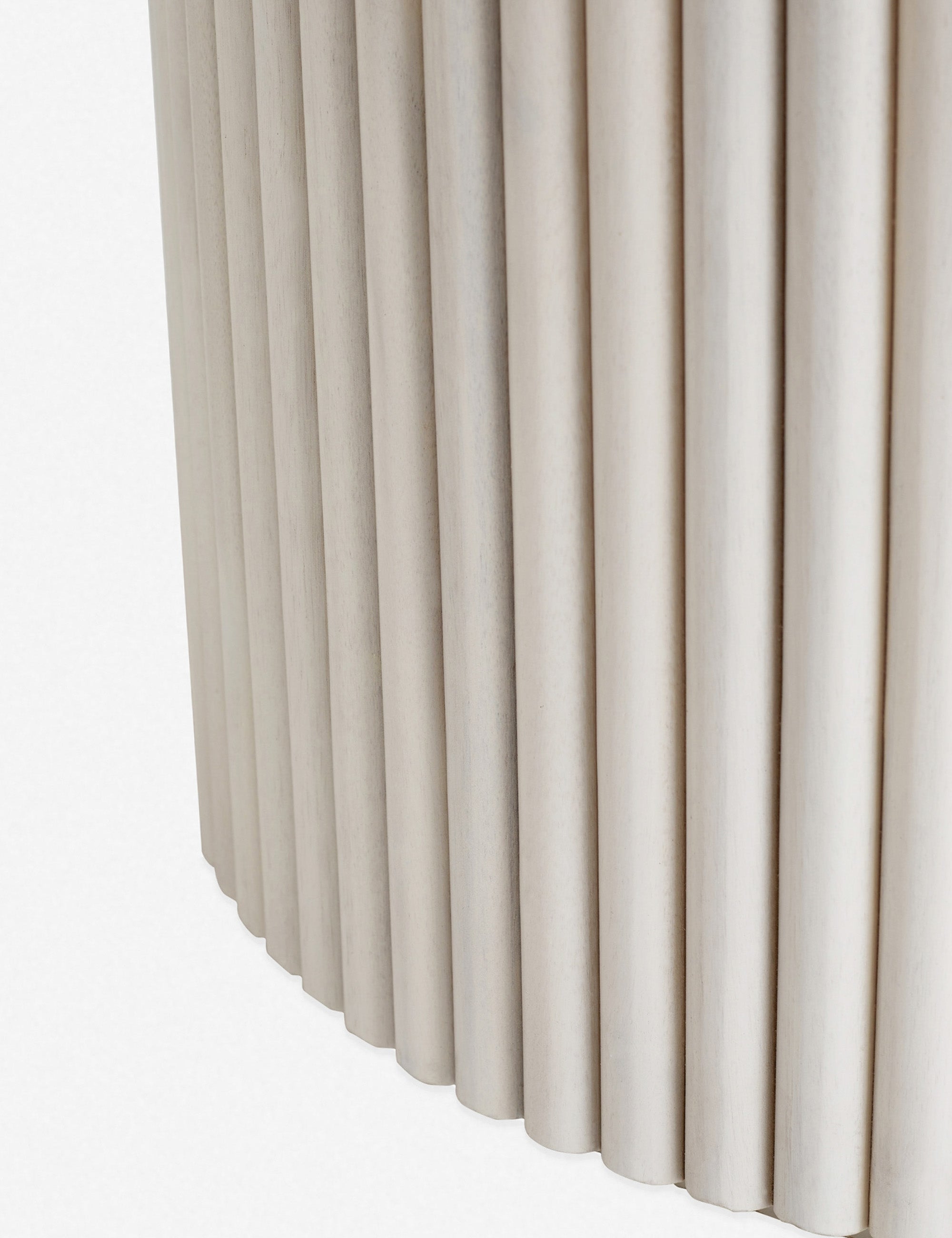 Close-up of the textured paneling of the white-washed acacia wood on the bottom of the pedestal base of the Rutherford round dining table.