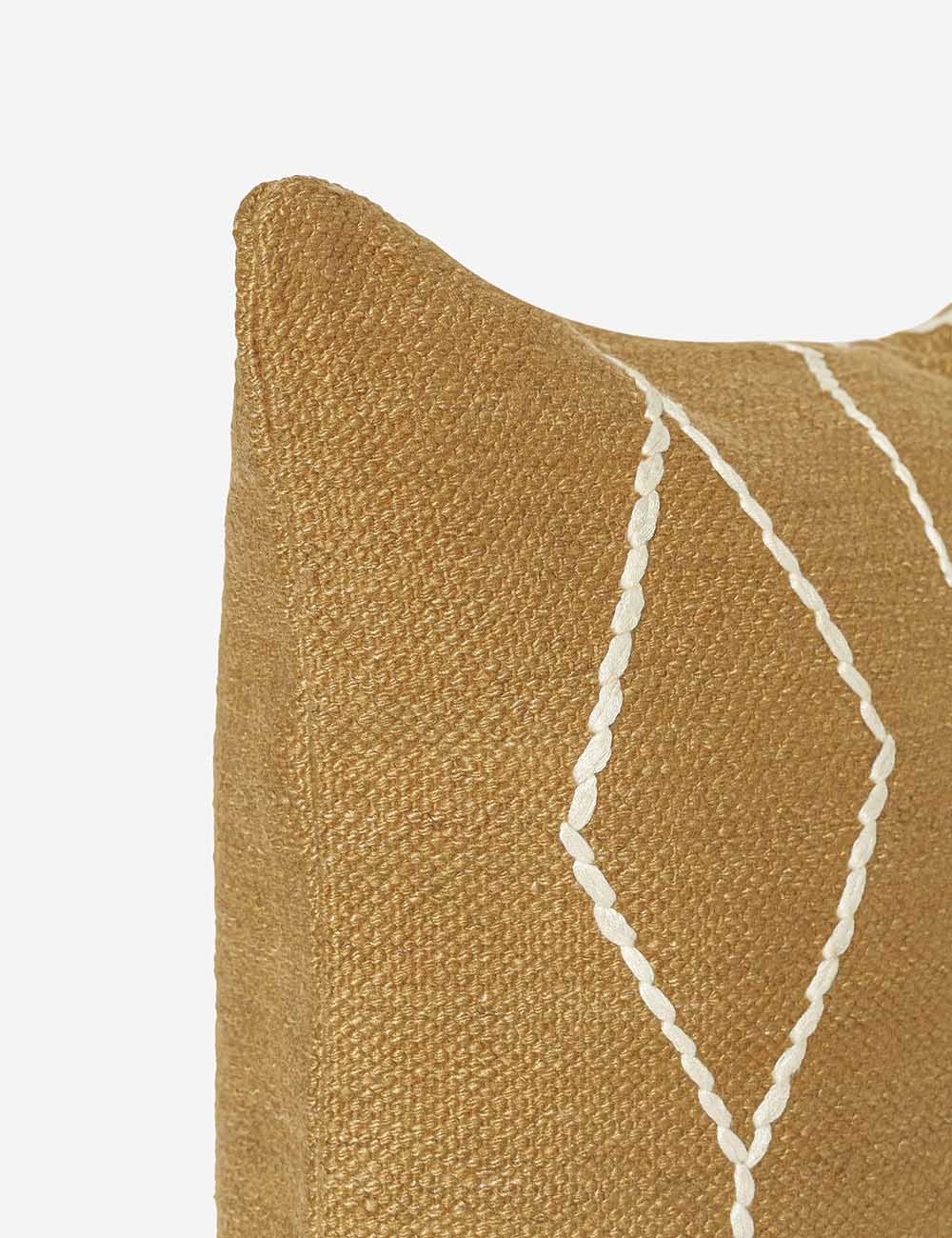 Close-up of the corner of the Moroccan ochre and natural beni ourain inspired square flat weave pillow by Sarah Sherman Samuel
